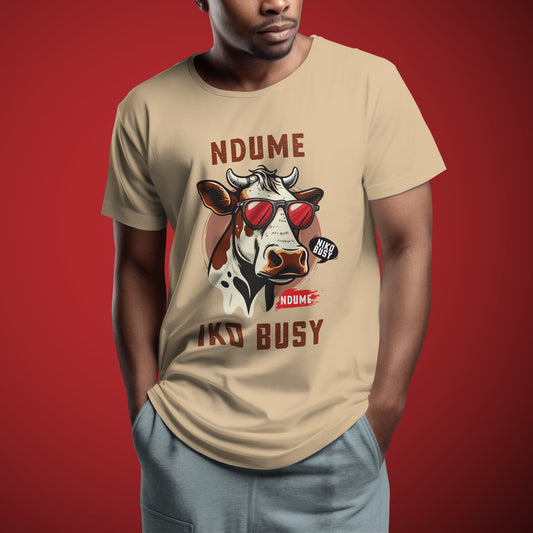 Beige Ndume Iko Busy tee – Kenyan graphic shirt with cow illustration and Swahili text